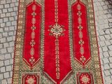 un tapis rouge posé sur un sol pavé, orné d'une croix