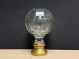 une image représentant un vase en verre avec un socle doré posé sur une table