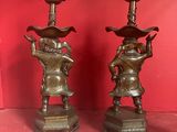 pair of antique bronze figurines of a boy and a girl on a pedestal