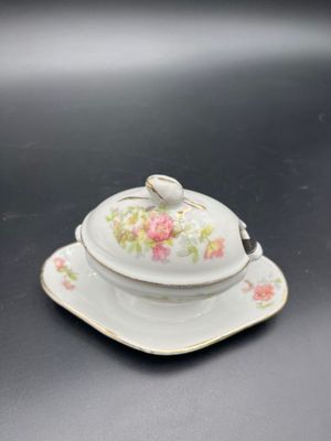 une petite assiette blanche ornée d'une fleur rose