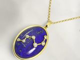 un gros plan sur un collier orné d'un signe du zodiaque