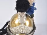 un casque doré orné d'une plume rouge, blanche et bleue