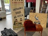 une chaise rouge au milieu d'une pièce, à côté d'un panneau