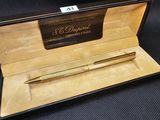 un stylo doré dans un coffret noir sur fond noir