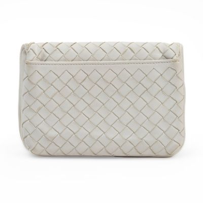 the white clutch bag has a woven design on the front of it