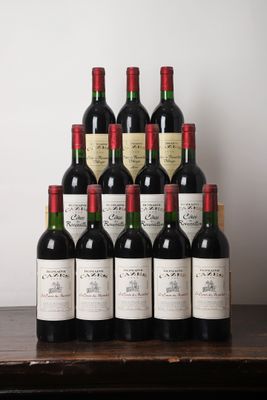 des bouteilles de vin rouge sont posées sur une table en bois devant un mur blanc