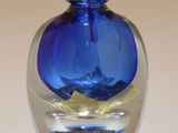 une bouteille en verre bleu ornée d'une feuille d'or