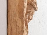 a sculpture of a man on the wall next to a clock