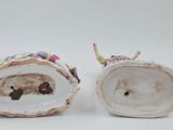 two figurines that are sitting on a white surface