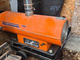 un chauffage au gaz de couleur orange posé dans un coin d'un immeuble