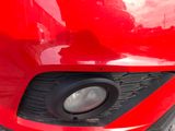 a close up of a red car ' s headlight and front bumper