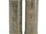 pair of old metal containers sitting on top of a white surface