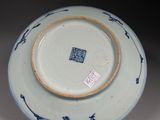 a blue and white plate sitting on a stand on a table