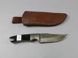 a knife and sheath on a table next to each other