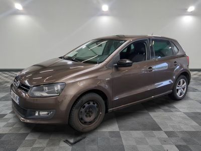 la voiture marron est garée sur un sol en damier dans le garage