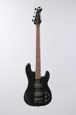 a black electric bass guitar hanging from a white wall