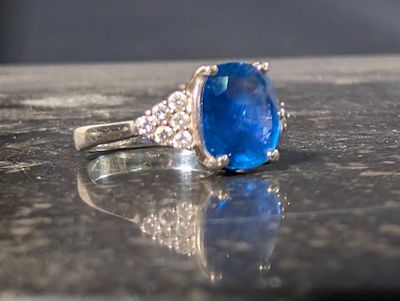 une photo d'une bague en pierre bleue posée sur une table