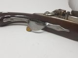 an old gun with a wooden handle on a white surface