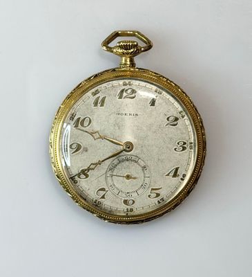a gold pocket watch on a white surface