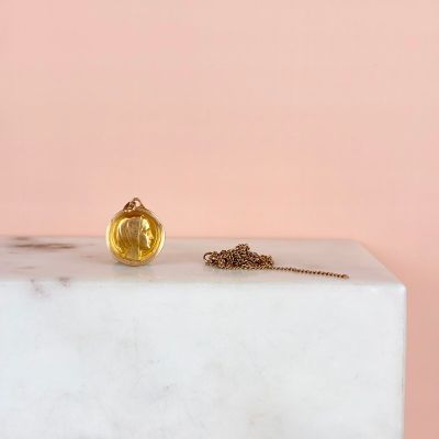 the gold ball is sitting on top of a white marble block
