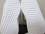 the soles of a pair of white shoes on a black table