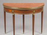 an oval mahogany table with brass inlays
