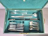 a green box with silverware in it on a table