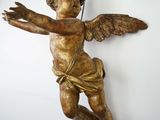 an image of a statue of an angel hanging from a chain