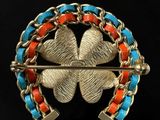 a close up of a broochle with a four leaf clover on it