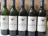 six bottles of wine are lined up in a row on a table