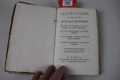 quelqu'un tient un livre ouvert sur lequel est accrochée une étiquette rouge