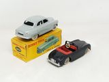 two toy cars sitting next to each other on a white surface
