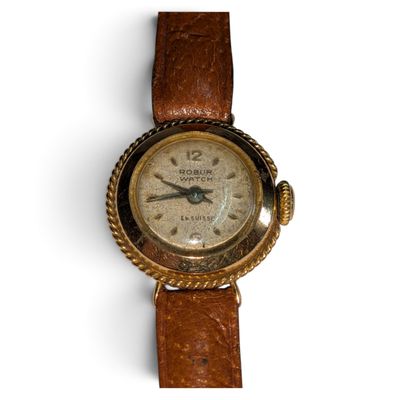 une vieille montre-bracelet avec un bracelet en cuir marron sur un fond blanc