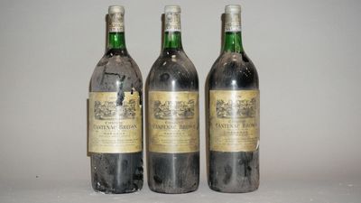 trois bouteilles de vin posées sur une table l'une à côté de l'autre