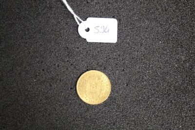 a gold coin and a white tag on a black surface