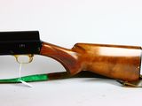 a wooden rifle with a green handle on a white background