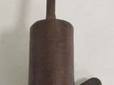 a metal object with a wooden handle hanging on a wall