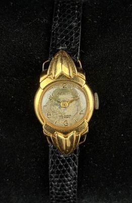 an image of a close up of a wrist watch on a black surface