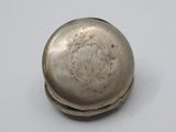 an old silver pill case sitting on top of a white table