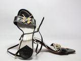 une image représentant une paire de chaussures noires et dorées posées sur une surface blanche