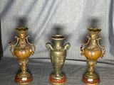 three gold vases sitting on top of a table next to each other