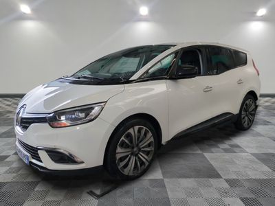 une voiture blanche garée dans un garage au sol en damier