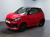 La voiture rouge est garée dans une grande pièce au sol noir.