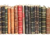 de nombreux livres anciens alignés les uns à côté des autres sur une étagère