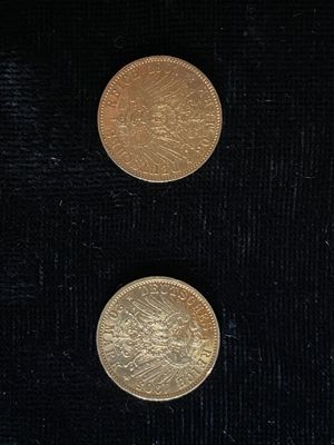 deux pièces d'or reposent sur une surface noire