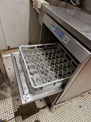 un lave-vaisselle ouvert au milieu d'une cuisine sale