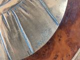 a close up of a clock on a wooden table