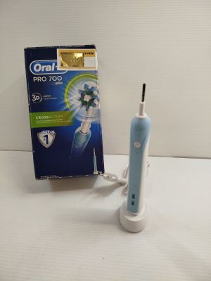 a blue and white electric toothbrush next to a box of toothpaste