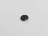 a green sapphire stone on a white surface