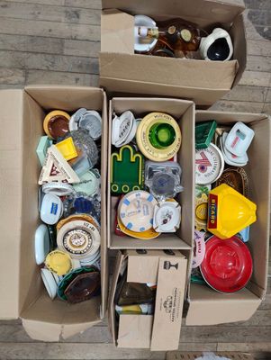 two cardboard boxes filled with assorted items on a wooden floor